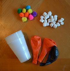 there are some candy and plastic cups on the wooden table next to eachother