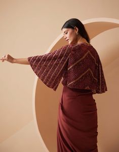 Layers for this season? This ethnic maroon jacket set is a perfect ensemble makes it possible with a lightweight organza cape, drape dhoti pleated style skirt and cropped blouse with hand embroidered katdaana and sequins embroidery. The jacket is speckled with the same embroidery work all around and extravagant bell sleeves, lending subtle yet stylish look. Organza Cape, Maroon Skirt, Maroon Jacket, Trendy Outfits Indian, Fabric Skirt, Beads Embroidery, Padded Blouse, Draped Skirt, Pattern Embroidery