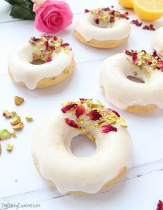 several donuts with white frosting and sprinkles are arranged on a table