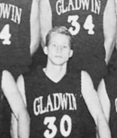 an old black and white photo of three men in basketball uniforms with numbers on them