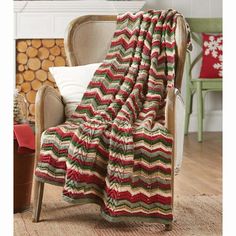 a chair with a blanket on top of it in front of a fire place and christmas tree