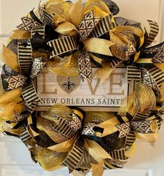 a new orleans saints wreath hanging on the front door with love is in the air