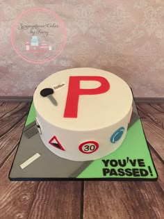 a cake that is sitting on top of a wooden table and has a parking sign on it