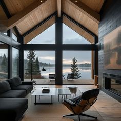 a living room with large windows and a view of the lake in the back ground