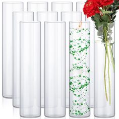 six tall vases with red roses in them and green dots on the bottom are lined up next to each other