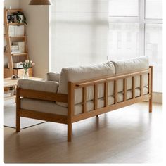 a wooden couch sitting in front of a window