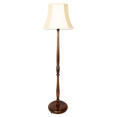 a wooden floor lamp with a white shade