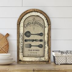 an old fashioned sign with spoons and utensils on top of a wooden table