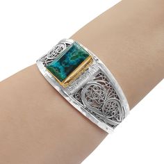 A stunning, delicate Gold filled and Sterling silver bracelet, set with natural Eilat Stone as the jewel's focal point. The natural Eilat stone is characterized by shades of blue and green created by the copper minerals embedded within the original rock. As such, no two stones are the same - the stone's colors and patterns vary depending on the particular stone used and the way it was excavated. This beautiful bracelet was made by delicate filigree work, created in the traditional Yemenite filig Elegant Cuff Bracelet With Natural Stones, Elegant Natural Stones Cuff Bangle Bracelet, Elegant Natural Stone Cuff Bangle, Elegant Natural Stones Cuff Bracelet, Elegant Green Cuff Bracelet With Natural Stones, Elegant Turquoise Cuff Bracelet With Gemstone, Elegant Turquoise Cuff Bracelet With Natural Stones, Elegant Turquoise Sterling Silver Oyster Bracelet, Elegant Turquoise Gemstone Sterling Silver Bracelet