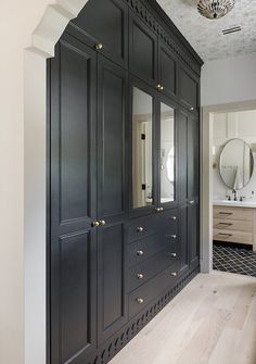 a large black cabinet in the middle of a room with mirrors and lights on it