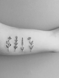 a person's arm with three different flowers on it