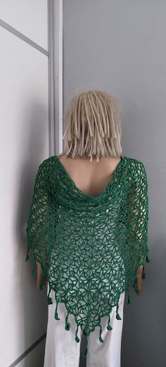 a woman wearing a green crochet shawl