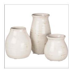 three white vases sitting next to each other