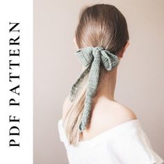 a woman with long hair wearing a green knitted bow in her back's ponytail