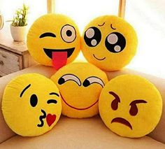 four yellow smiley face pillows sitting on top of a couch