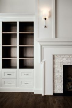 a white bookcase in front of a fireplace