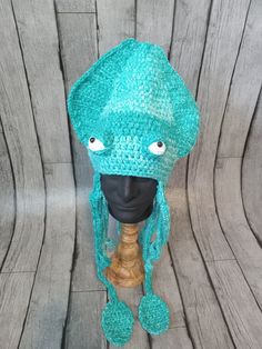 a crocheted hat on top of a wooden mannequin's head