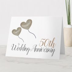 an anniversary card with two heart balloons on it and the words 50th wedding anniversary written in gold