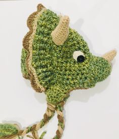 a crocheted green hat with horns on it