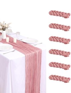 the table is set with plates and napkins on it, along with pink cords