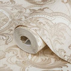 a roll of wallpaper with an intricate design on it's side, in beige and white