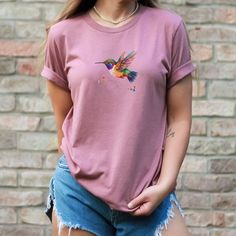 Hummingbird Shirt Watercolor Bird T-Shirt Nature Lover T Shirt Wildflower Shirt Bird Lover Gift for Her Hummingbird Lover Gift This classic unisex jersey short sleeve tee fits like a well-loved favorite. Soft cotton and quality print make users fall in love with it over and over again. These t-shirts have-ribbed knit collars to bolster shaping. The shoulders have taping for better fit over time. Dual side seams hold the garment's shape for longer.  .: 100% Airlume combed and ringspun cotton (fiber content may vary for different colors) .: Light fabric (4.2 oz/yd² (142 g/m .: Retail fit .: Tear away label .: Runs true to size Thanks for visiting my shop! Please feel welcomed to check out my other items in my shop at https://lylasshoppe.etsy.com. Kind Regards, Pam Summer Crew Neck T-shirt With Bird Print, Casual Crew Neck T-shirt With Bird Print, Casual Summer T-shirt With Bird Print, Mama Bird Shirt, German Shepherd Mom Shirt, Wildflower Shirt, Corgi Mom, Bird Shirt, Comfort Colors Tshirt