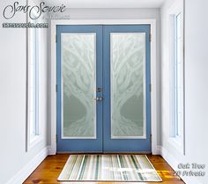 a blue front door with two glass panels and a rug on the floor next to it