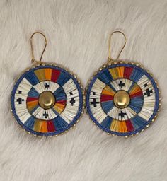 pair of earrings with multicolored designs on white fur