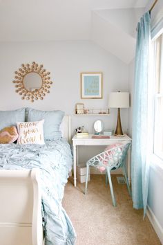 a bed room with a neatly made bed and a mirror on the wall above it