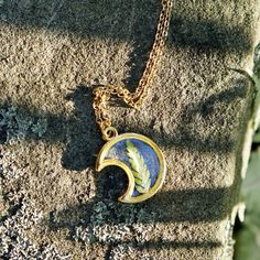 "A crescent moon pendant holds a tiny fern frond in this gold plated necklace. Jewelry grade resin encases the fern in the center of the pendant for a magical forest moon piece. Matching chain can be 18\" or 24\"- choose at checkout. Comes on a labeled card." Nature-inspired Moon Charm Pendant Necklace, Nature-inspired Necklace With Moon Charm Round Pendant, Nature-inspired Necklace With Round Moon Charm Pendant, Nature-inspired Round Pendant Necklace With Moon Charm, Nature-inspired Round Pendant Jewelry With Moon Charm, Moon Forest, Fern Necklace, Forest Moon, Moon Gold