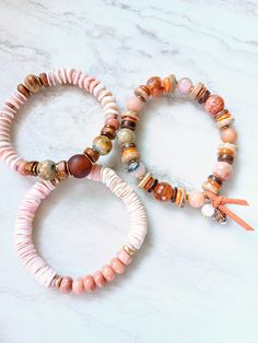 This trio is sweet, serene, cozy, and peaceful. Beautiful rosé, salmon, albaster, barely blush, peach, touches of mustard, rust, and the palest lavender in these mixed medium stack bracelets. Several gemstone beads in different sizes, shapes, and colors. Peach Aventurine, Sunstone, Laughing Agate, Bone beads, Pink Oyster shell, pearl, natural coconut, rust wood disks, and mixed metals. Unique and stunning. The item/s pictured is the item you will receive. Bracelets is 7.0" to 7.5" in length. HavSolStudio on ETSY | Mixed media . Earthy elegance . Great texture . Beach inspired . Coastal calm . A little rustic . Worldly . Alluring . Recycled glass . Reuse . Repurpose . Statement making . One-of-a-kind . Quality gemstones . Wood . Nut & bone beads . Ethiopian metals . Handmade . Imaginative . Pink Natural Stones Bracelet For Everyday, Everyday Pink Bracelets With Natural Stones, Everyday Pink Natural Stone Bracelets, Everyday Pink Beaded Bracelets With Natural Stones, Bohemian Peach Bracelets For Gifts, Bohemian Peach Bracelets For Gift, Peach Bohemian Bracelet For Gifts, Peach Bohemian Bracelet For Gift, Peach Aventurine