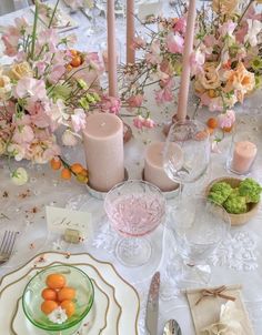 the table is set with flowers and candles