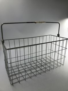 a metal basket with a light on the side and a white wall in the background