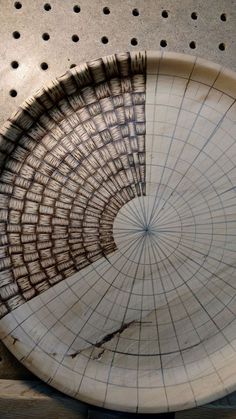 a white plate with holes in it sitting on a counter top next to a metal grate