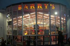 the entrance to barry's at night with people standing outside and looking into the window