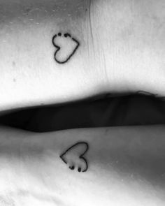 two people with matching tattoos on their wrists, one has a heart and the other has