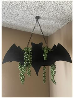 a bat shaped planter hanging from the ceiling