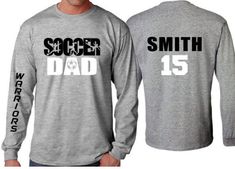 Soccer Dad Shirt | Soccer Long sleeve (one sleeve/one word only) Shirt | Customize your team & colors PLEASE READ BEFORE ORDERING WE CANNOT RUSH ORDERS OR CREATE NEW DESIGNS DURING PEAK SEASON AUG - MAY. IF YOU NEED TO CANCEL PLEASE DO SO WITHIN 24HRS Please read full description before ordering we cannot be responsible for mistakes made by not reading the full description. ORDERING INSTRUCTIONS: 1. Select your Garment Size/Color Each size must be selected separately. Please do NOT leave a l Athletic Heather Long Sleeve T-shirt With Letter Print, Long Sleeve T-shirt For Baseball Game Day, Long Sleeve T-shirt With Team Name For Sports Season, Long Sleeve Tops With Team Name For Sports Events, Sports Event Long Sleeve Tops With Team Name, Long Sleeve T-shirt For Sports With School Spirit, Long Sleeve Sports Event Tops With Team Name, Long Sleeve T-shirt With Team Name For Game Day, Varsity Long Sleeve T-shirt With Team Name