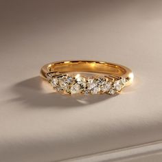 a gold ring with five diamonds on it