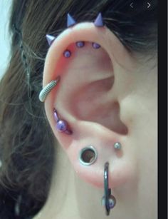 an ear with some piercings attached to it's sides and two screws in the middle