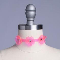 Delicate choker with a dimensional triple floral design in neon pink PVC. Collar is uv-reactive. Fit is adjustable with buckle in back. Collar is 1/2" wide. Silver toned nickel-coated hardware. SMALL/MEDIUM (11-13")MEDIUM/LARGE (13-15")LARGE/X-LARGE (15-17") Custom sizing available. All pieces are MADE TO ORDER. If your measurements fall outside these standards or you are unsure of what size to order, select "CUSTOM" and include your measurements in the notes upon checkout so we can adjust for a Adjustable Pink Choker For Festivals, Adjustable Rave Choker For Festival, Pink Choker Jewelry For Spring, Pink Summer Festival Choker, Pink Choker For Summer Festival, Pink Adjustable Choker For Party, Adjustable Pink Choker For Party, Adjustable Rave Style Choker, Pink Rave Jewelry For Festival