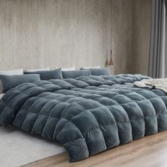 a large bed sitting on top of a hard wood floor next to a wooden wall