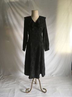 "vintage 1990s handmade dress shiny black jacquard fabric w/floral pattern  zip back ruffle collar long sleeve empire waist ruffle neck unlined good vintage condition, light wear no size tag-see below measures, lying flat, shoulder-17\" chest-17\" waist-15\" hip-21\" sleeve-22 1/2\" length-48\" (4')" Vintage V-neck Winter Dress, Fitted Vintage V-neck Dress With Ruffles, Black Vintage Dress With Ruffles For Fall, Fitted V-neck Vintage Dress With Ruffles, Fitted Gothic Vintage Dress With Long Sleeves, Fitted Long Sleeve Black Vintage Dress, Long Sleeve Vintage Dress With Ruffles For Fall, Vintage Ruffled Dress For Fall Party, Fitted Vintage Winter Dress