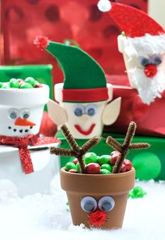 some christmas decorations made out of clay and fake snowman faces are in a flower pot