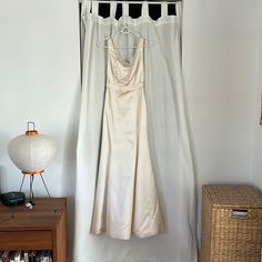 a dress hanging on a hanger in front of a window