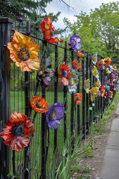 an iron fence with colorful glass flowers on it