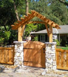 an outdoor wooden gate with stone pillars