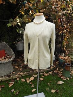 Vtg Ecru 1970's Ladies Ribbed Cardigan|Ladies Retro Sears Sweater|Vtg Acrylic V Neck Cardigan Sweater sz S/M This is a terrific vintage retro ladies off-white ribbed cardigan sweater.  It is in amazing condition and looks to have been hardly worn if at all.  There is a deep V neck here with a horizonal ribbing to the acrylic fabric.  The sweater is a longer length and has 2 small front pockets. Condition here is very good with one small snag I detected that can be worked back into the fabric. Me