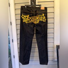 This Pair Of Jeans From Rocawear Is Perfect For Anyone Looking To Add A Touch Of Hip-Hop Style To Their Wardrobe. With A Baggy Fit And 5-Pocket Design, These Jeans Are Both Stylish And Practical. These Denim Jeans Are Made From 100% Cotton For Maximum Comfort And Durability. The Jeans Feature A Solid Pattern, Zip And Button Closure, And Come In A Dark Wash. They Are Machine Washable, Making Them Easy To Care For. The Waist Size Is 38 Inches, With A High Rise Of Greater Than 12 Inches. The Inseam Measures 33 Inches, And They Are A Size 38. They Come In Black Color, With A Rocawear Logo Accent Embroidered Across The Seat Of The Pants. These Jeans Are Perfect For Winter, Summer, Fall, And Spr Rocawear Jeans, Y2k Jeans, Greater Than, Hip Hop Fashion, Baggy Fits, Solid Pattern, Pocket Design, Summer Fall, Waist Size