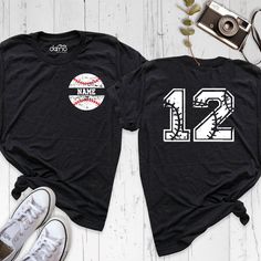 two baseball shirts with the number one and 2 on them, next to a pair of sneakers